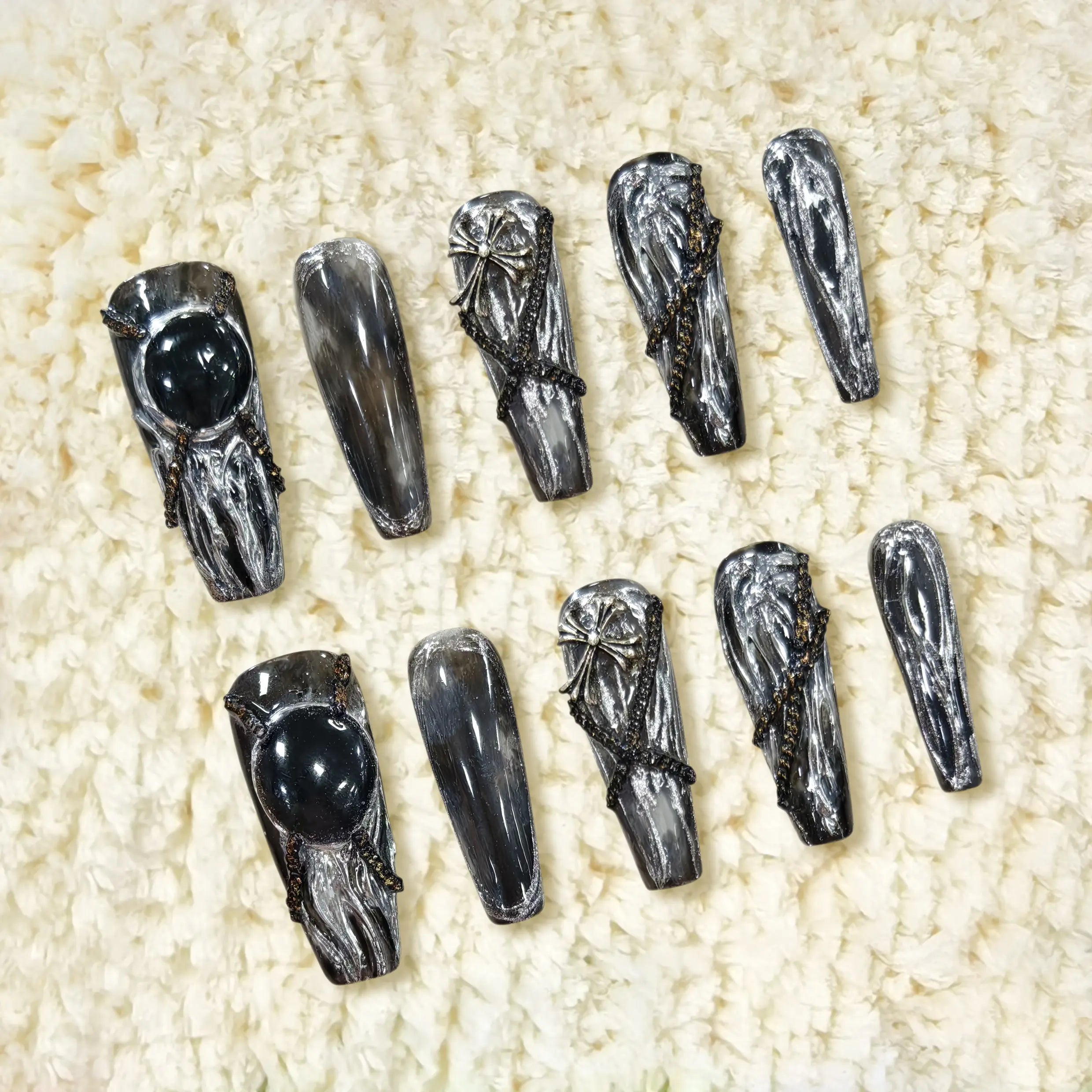 Black coffin press on nails with metallic silver textures and bold 3D gemstone accents in a gothic glam style.