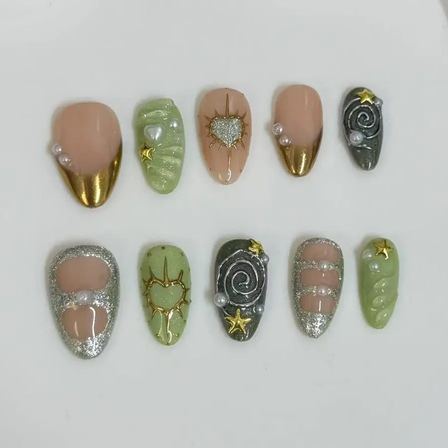 Medium almond press on nails in nude and olive green with gold foil, star, and swirl patterns.