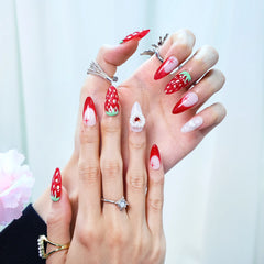 Hand model wearing almond press-on nails with ombré red to white gradient, 3D strawberry decor, and pearl heart embellishments