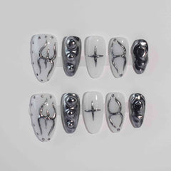Almond-shaped black press on nails with white and chrome accents, featuring wire detail for a futuristic look.