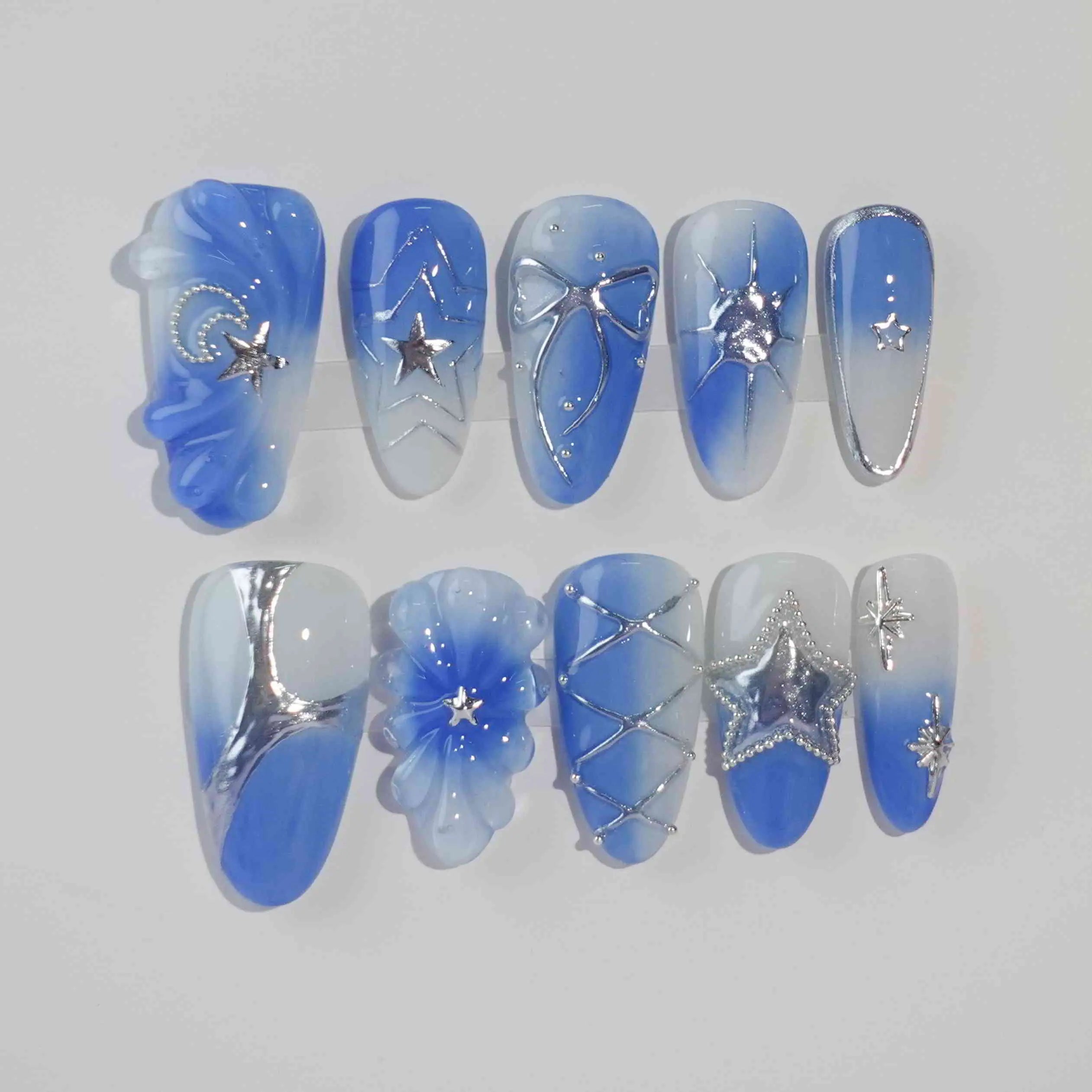 Medium blue almond press on nails with icy silver lines and embedded floral details.