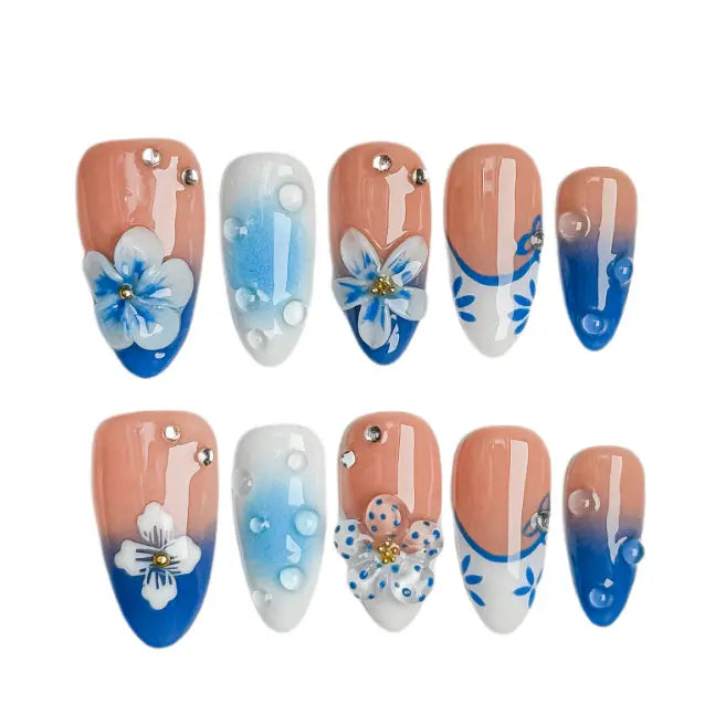 Medium almond french tip press on nails with blue daisy flowers and pearl decorations.