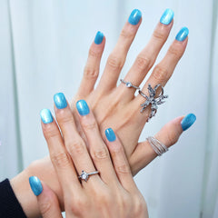 Hand wearing glacier blue press-on nails with a shimmer overlay