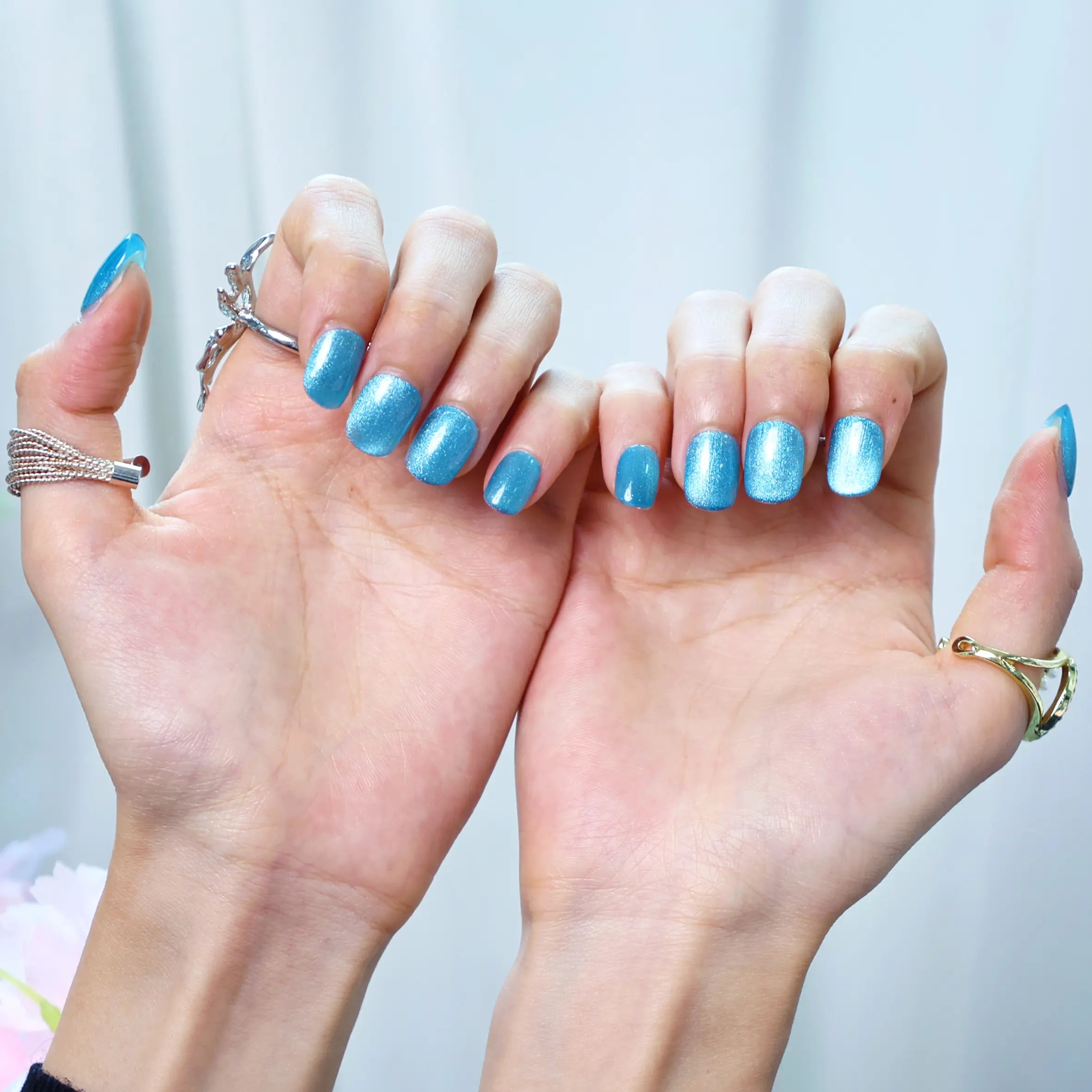 Styled nails with snowflake blue tones and sparkle texture