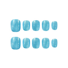 Short squoval-shaped press-on nails in shimmering glacier-blue with frosty sparkle, perfect for cool-toned, winter-inspired styles