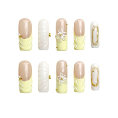 Coffin press on nails in butter yellow and white with 3D flower accents.