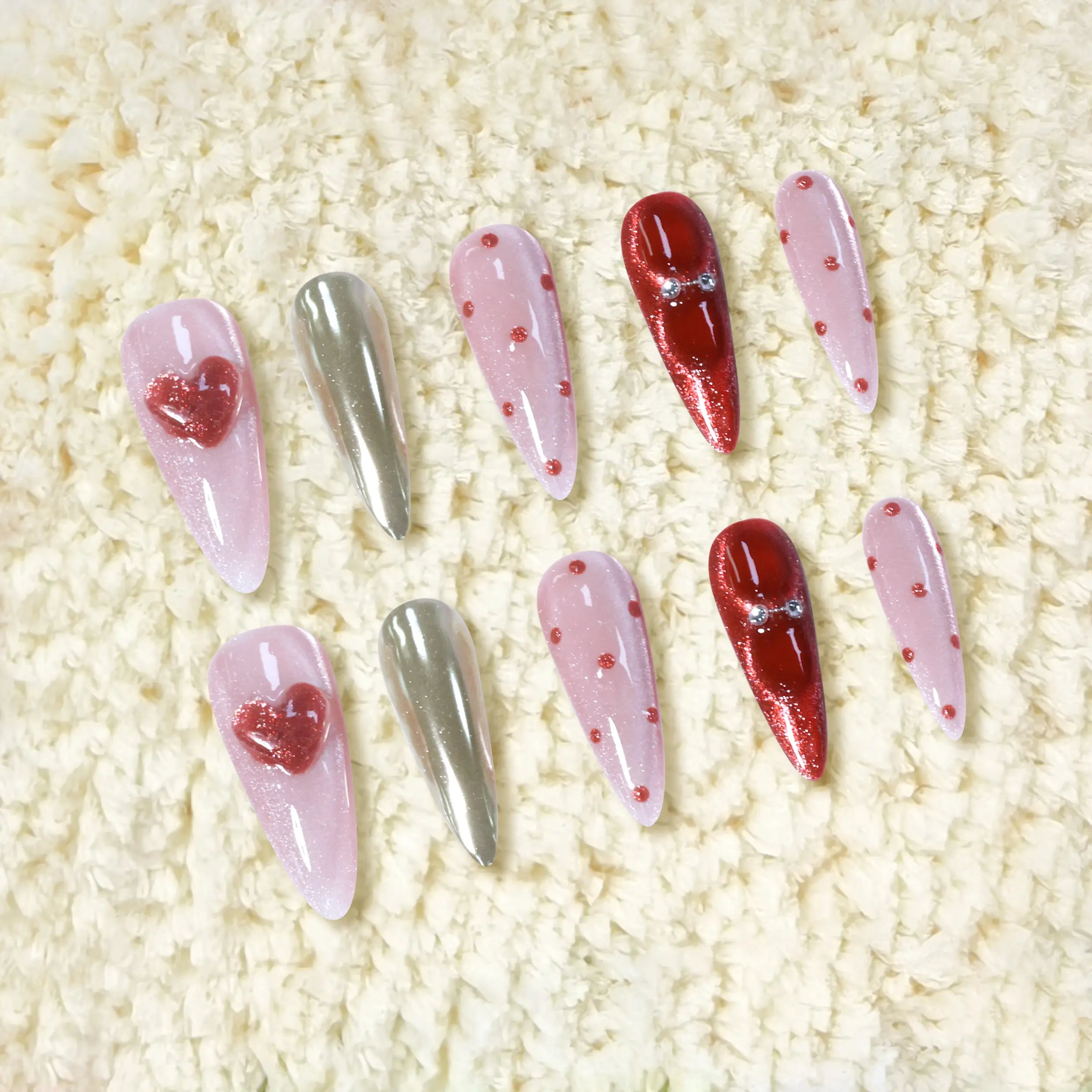 Handmade long stiletto press-on nails featuring shimmering pink, red glitter, gold chrome, and 3D heart accents for a playful, glamorous look.
