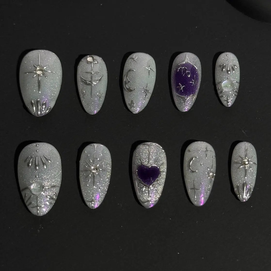 Medium almond press on nails with silver glitter, blue tones, and gemstone accents.