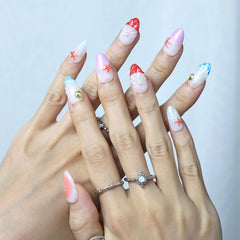 Summer press-on nails in coral ombré shades with pearl and shell-inspired accents