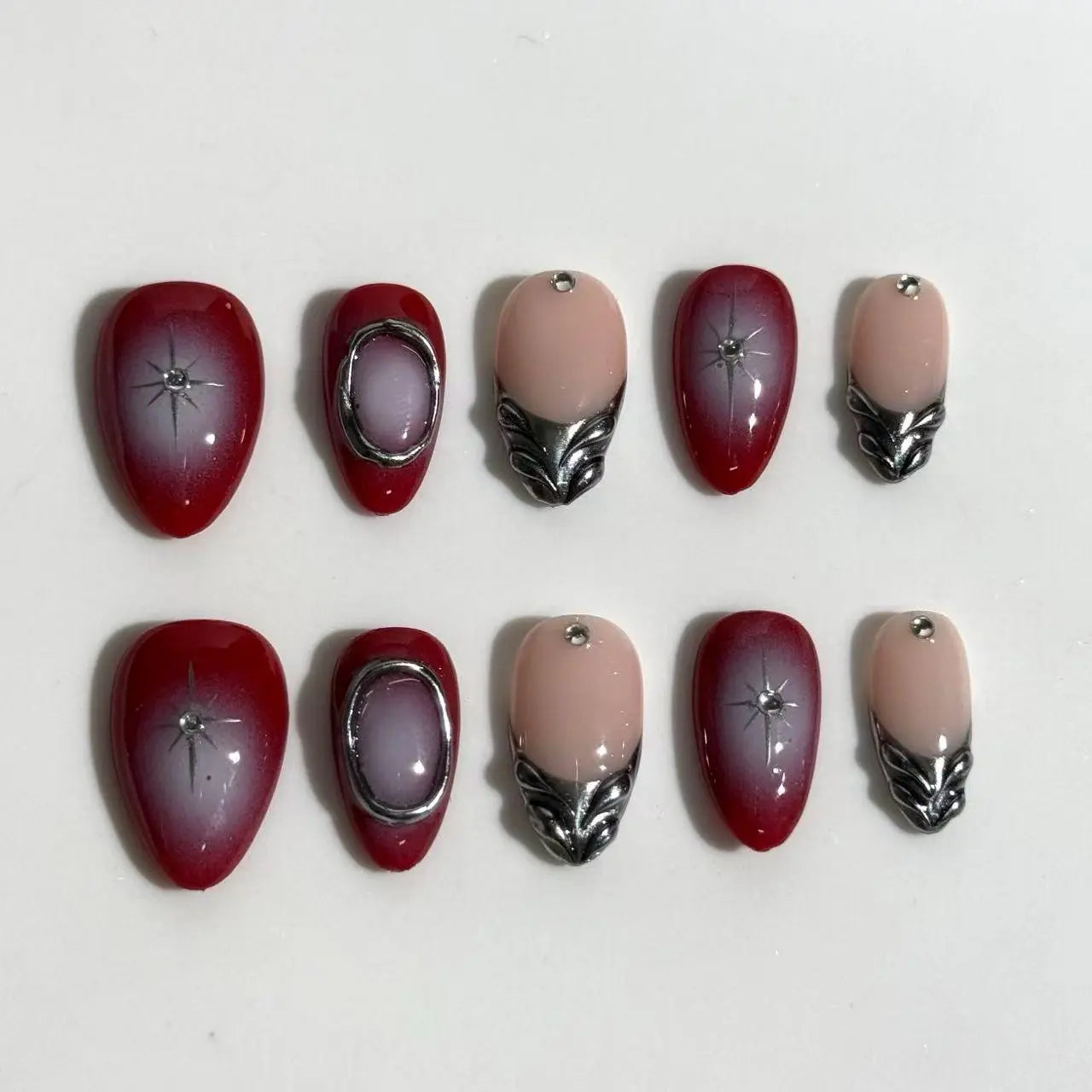 Medium almond-shaped red press on nails with french tips and rhinestone accents.