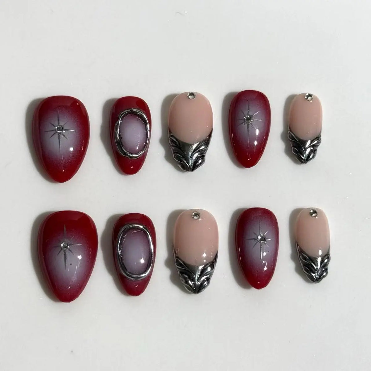 Medium almond-shaped red press on nails with french tips and rhinestone accents.