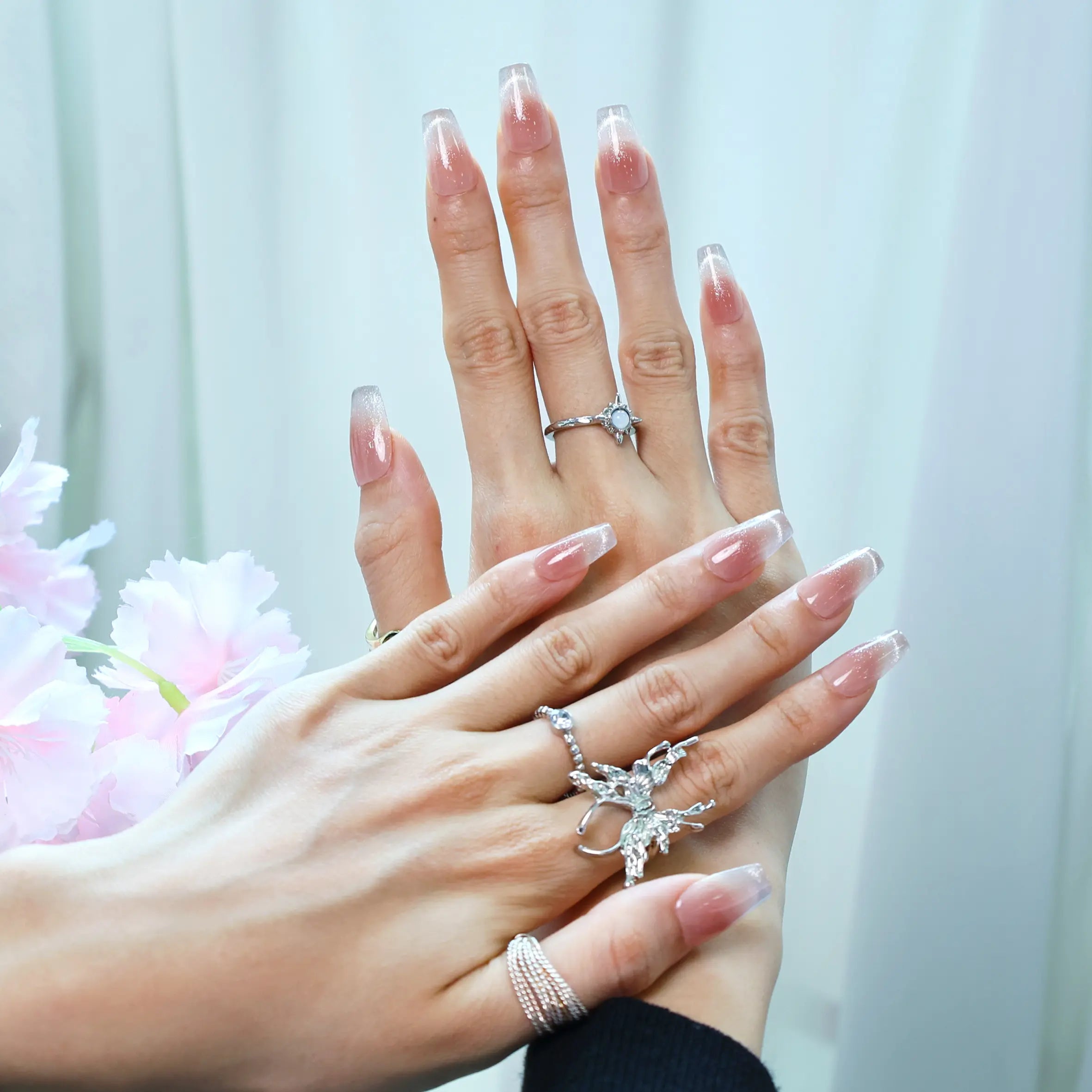 Nude ombré press-on nails with subtle glitter, worn on hand
