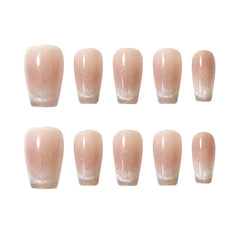 Nude squoval press-on nails with glitter ombré fade, combining french-tip style with subtle shimmer for summer elegance.