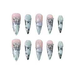 Pink stiletto-shaped press-on nails blending into silver chrome, with 3D ice textures, pearls, and metallic butterfly accents.