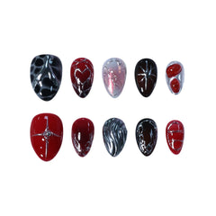 Fiery red and black short almond press-on nails with molten chrome, shattered-glass textures, and sculpted heart accents.