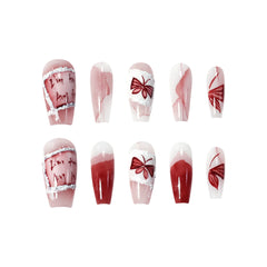 Medium coffin pink and red press-on nails with hand-painted bow and wing designs for an ethereal, romantic style.