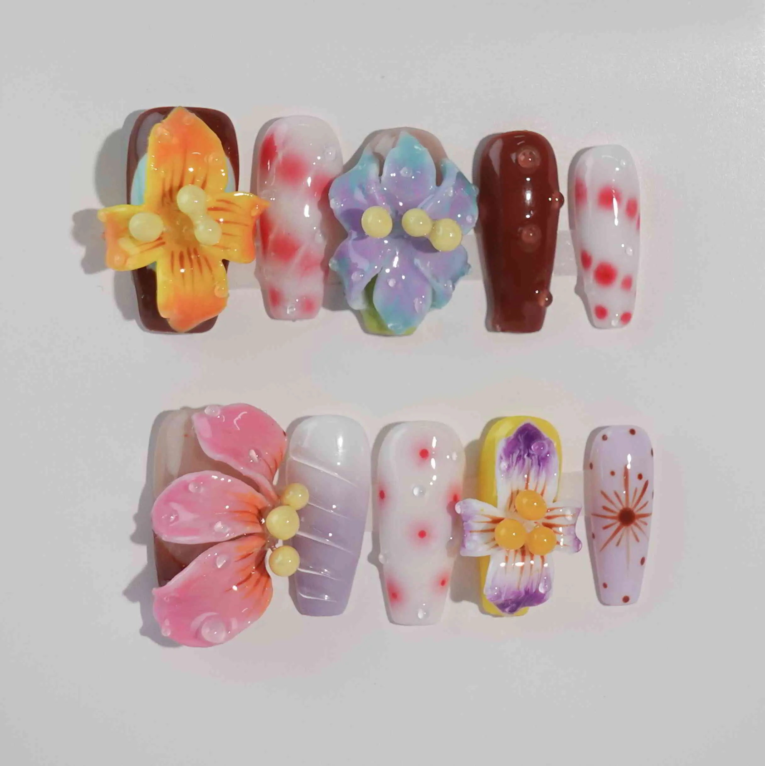 Long coffin press-on nails with oversized pink flowers, jelly textures, and pastel pink and blue tones—perfect for summer parties.