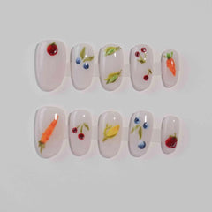 Clear medium oval press on nails with fruit and vegetable accents for a playful summer look.