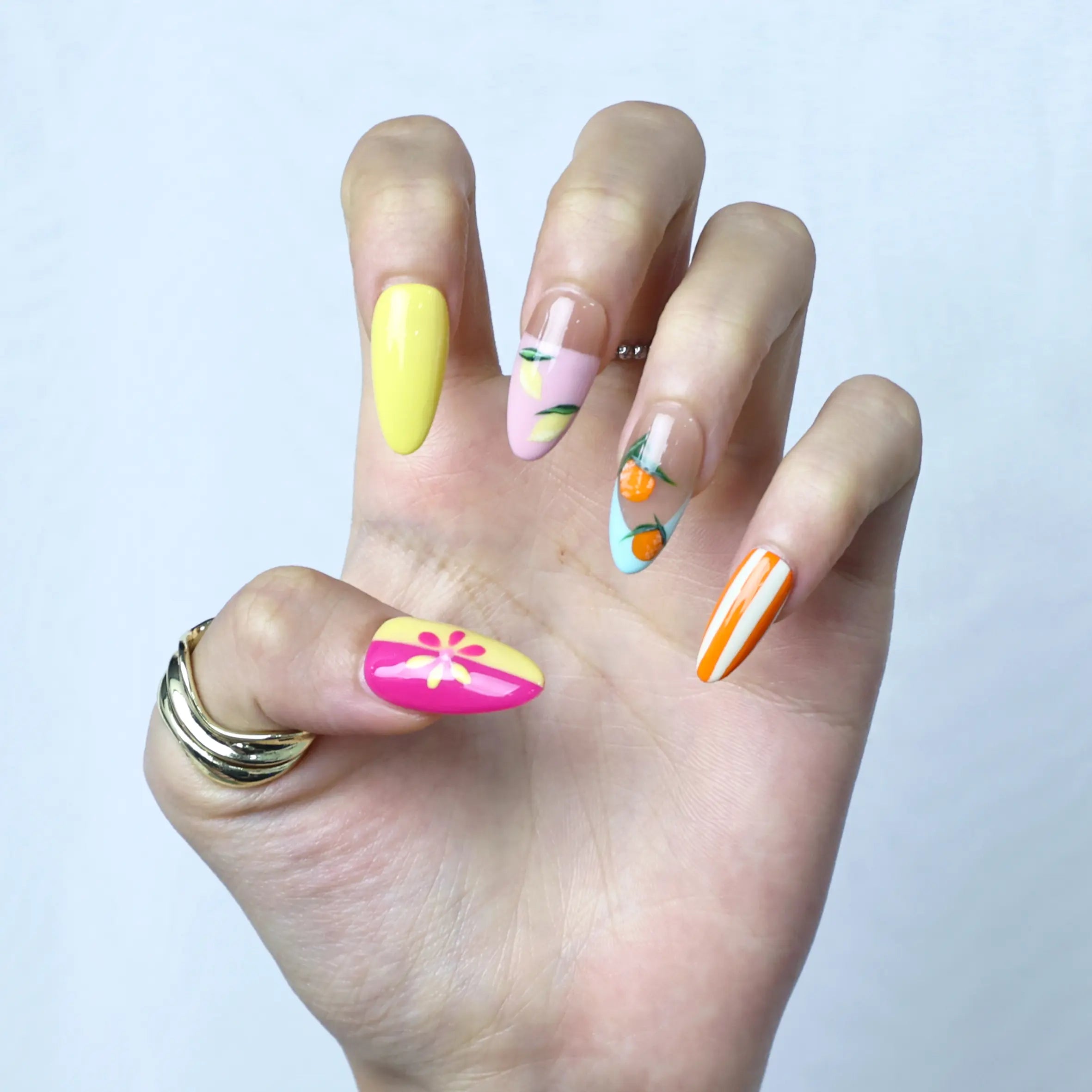 Side view of summer-inspired press-ons with citrus motifs and sunny orange and yellow gradients