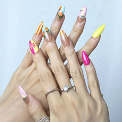 Bright almond nails with hand-painted orange fruits and lemon accents for a cheerful summer vibe
