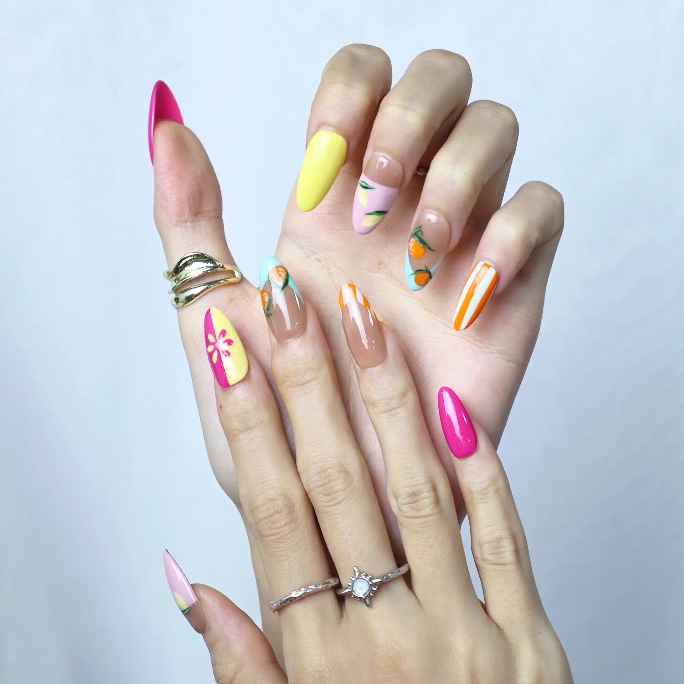 Fruity summer manicure in almond style with painted citrus slices and glossy top coat for a fresh finish