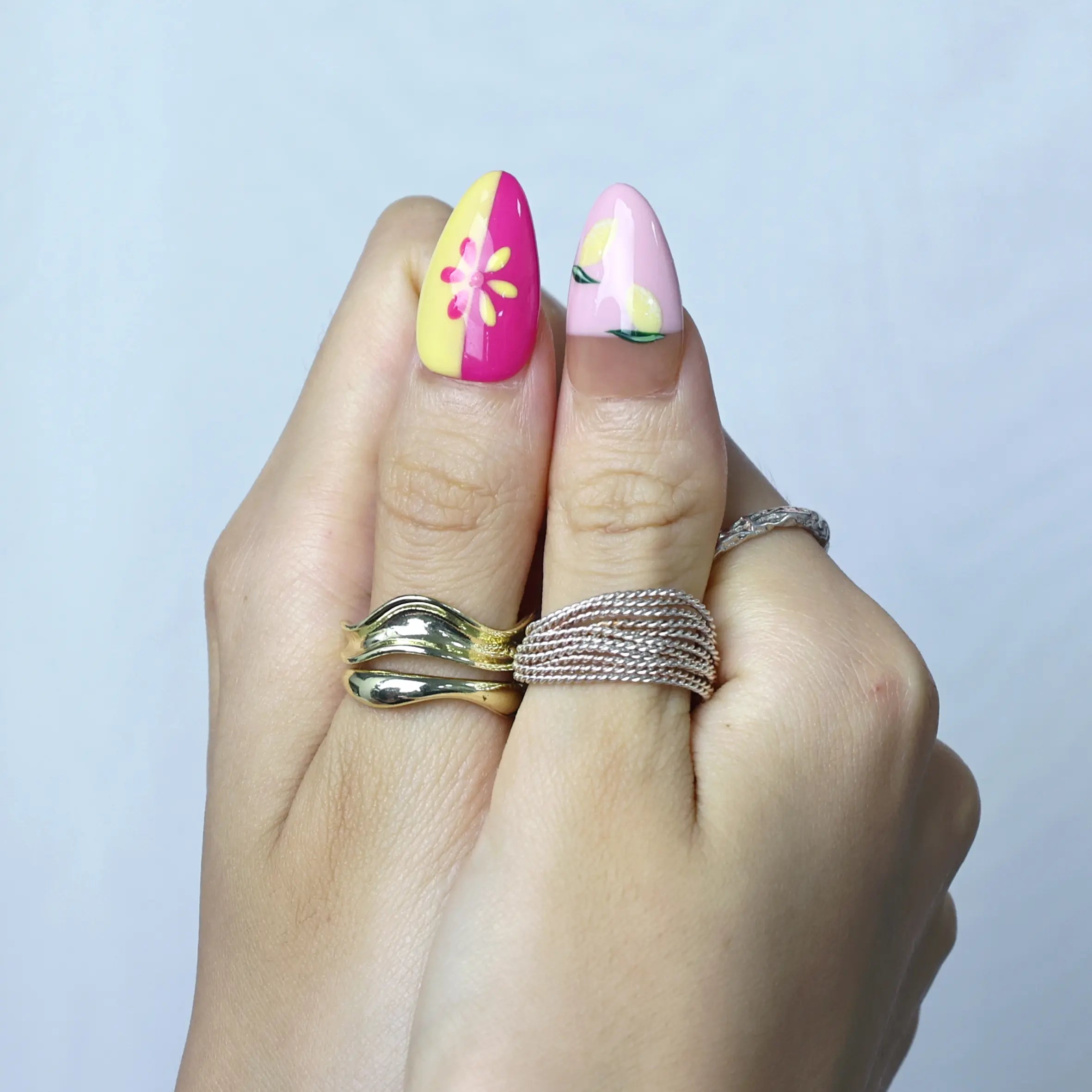 Close-up of glossy summer nails featuring juicy tangerine patterns and fresh citrus art in warm tones