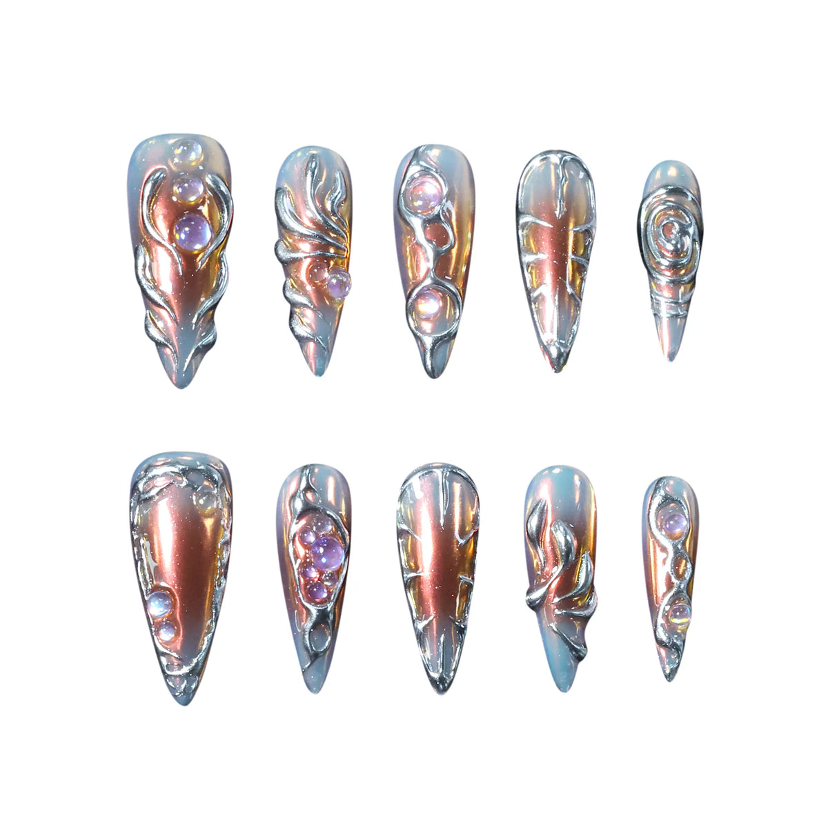 Long stiletto-shaped metallic press-on nails in burnished copper and silver tones with chrome and gem details, creating a molten 3D effect.