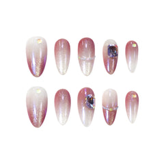 Medium almond press on nails in pink-to-white ombré with glitter and rhinestone accents, ideal for weddings or soft glam looks.