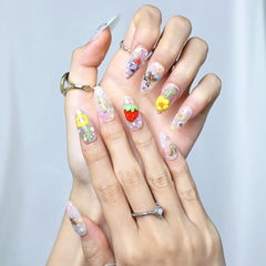Close-up of glittery pink nails featuring kawaii character accents, strawberries, and layered flowers