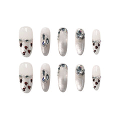 Long oval press on nails with sheer base, silver glitter ombré, and heart-shaped leopard spot accents for a bold summer glam style