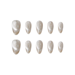 Golden champagne almond press-on nails with a soft cat-eye shimmer effect in medium length.