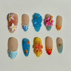 Blue almond press on nails with 3D tropical flowers, seashells, and starfish charms.