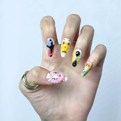 Close-up of kawaii press-on nails with bright characters, glossy finish, and raised eye embellishments