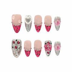 Pink almond press on nails with leopard print, glitter, 3D flowers, and pearl embellishments