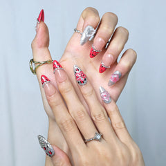 Hand model showing pink almond nails with leopard spots, glitter shimmer, and 3D floral accents