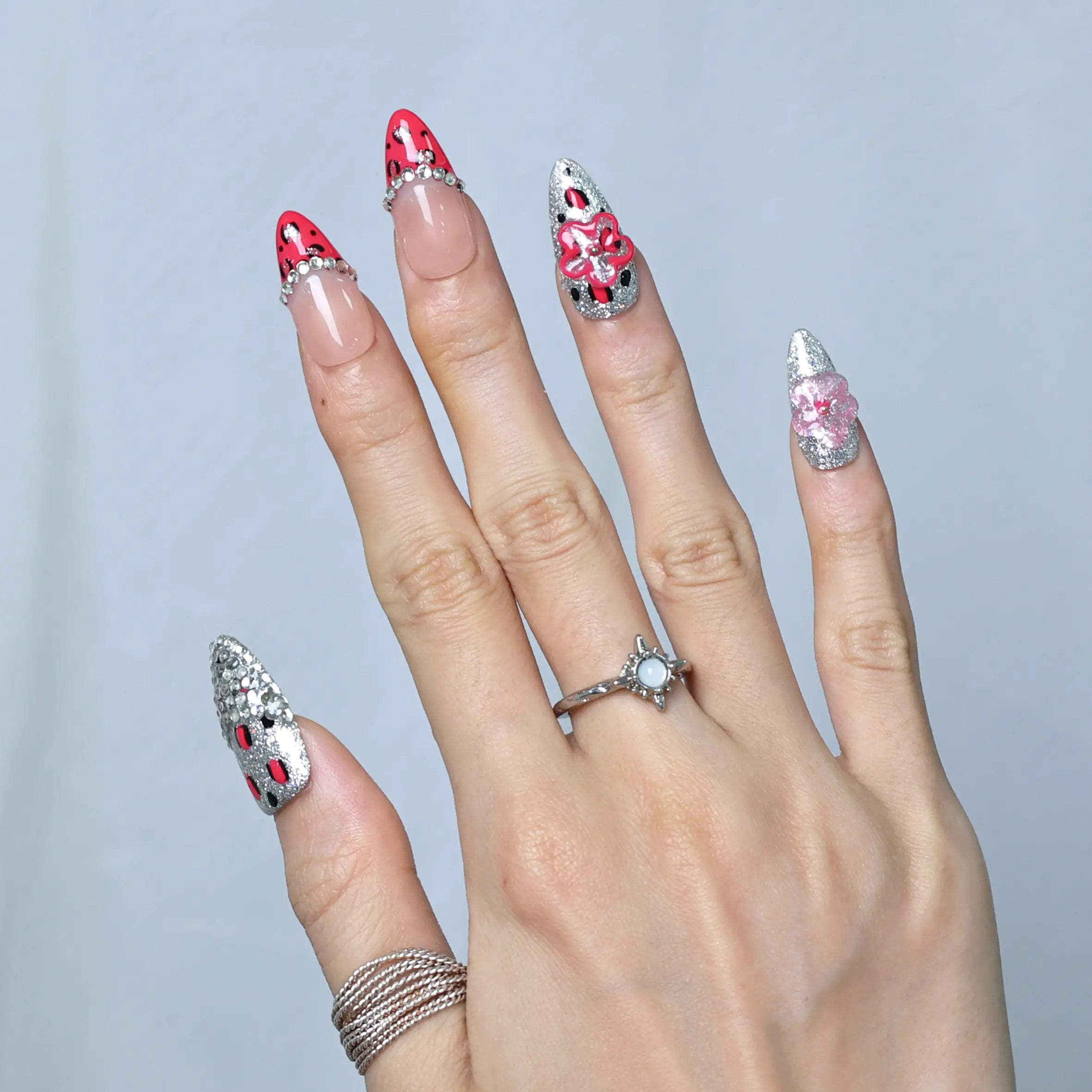 Statement nails with pink tones, glitter gradients, and pearl-embellished floral art