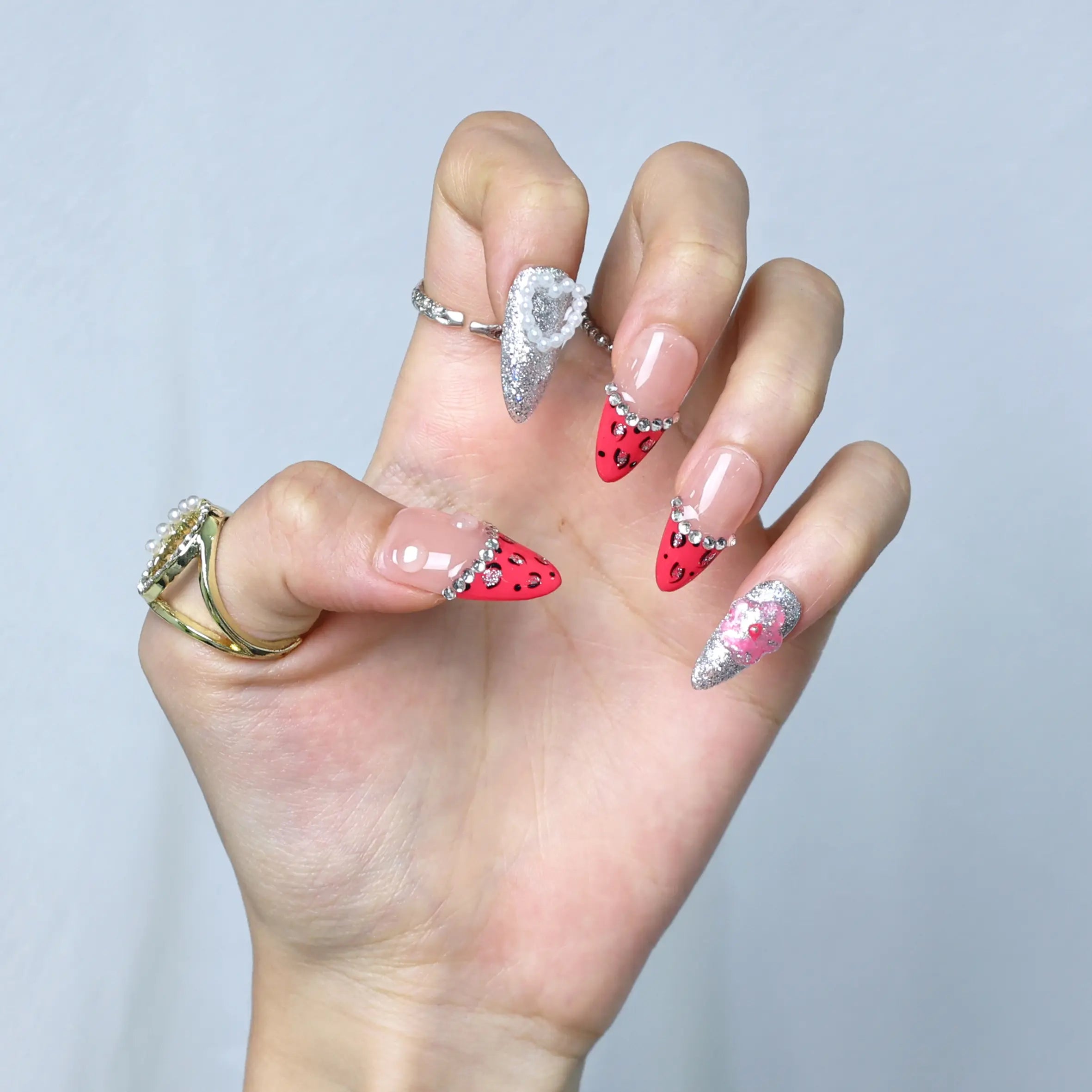 Press-on nail set worn by model featuring fierce leopard print with soft floral and pearl touches