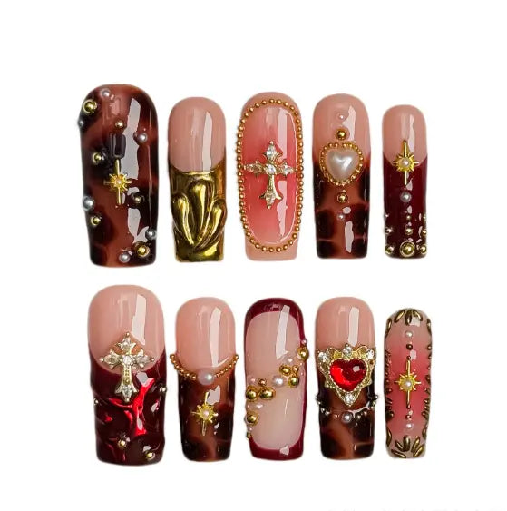 Red long press on nails with tortoiseshell texture, 3D hearts, and gold charm accents.