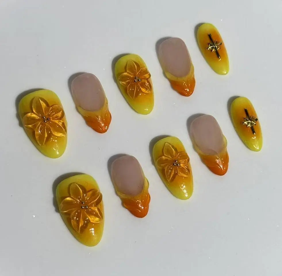 Almond-shaped summer press on nails with golden yellow and orange floral 3D designs.
