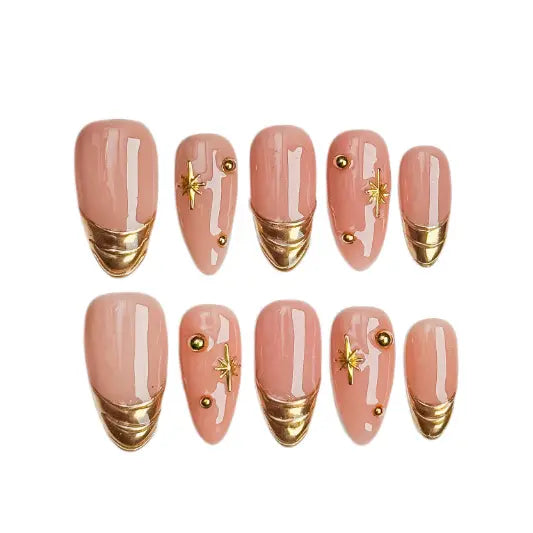Minimalist medium almond french tip press on nails in nude and gold with gemstone details.