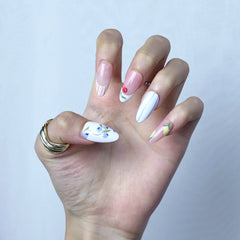 Close-up of glossy pink press-on nails with summer flowers and strawberry, cherry-inspired 3D elements