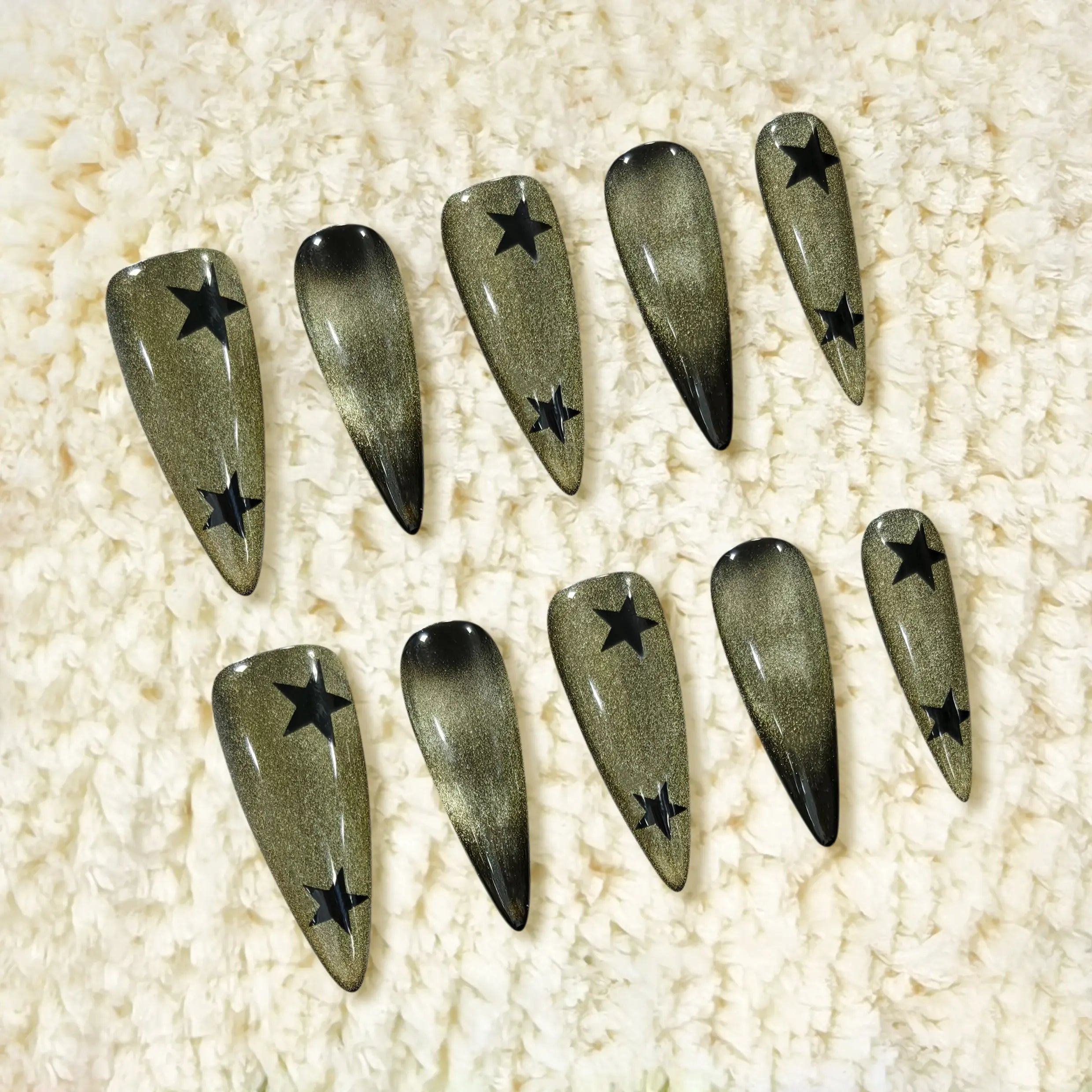 Long stiletto press on nails with black-to-gold shimmer gradient and star embellishments