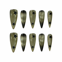 Long stiletto press on nails with black-to-gold shimmer gradient and star embellishments
