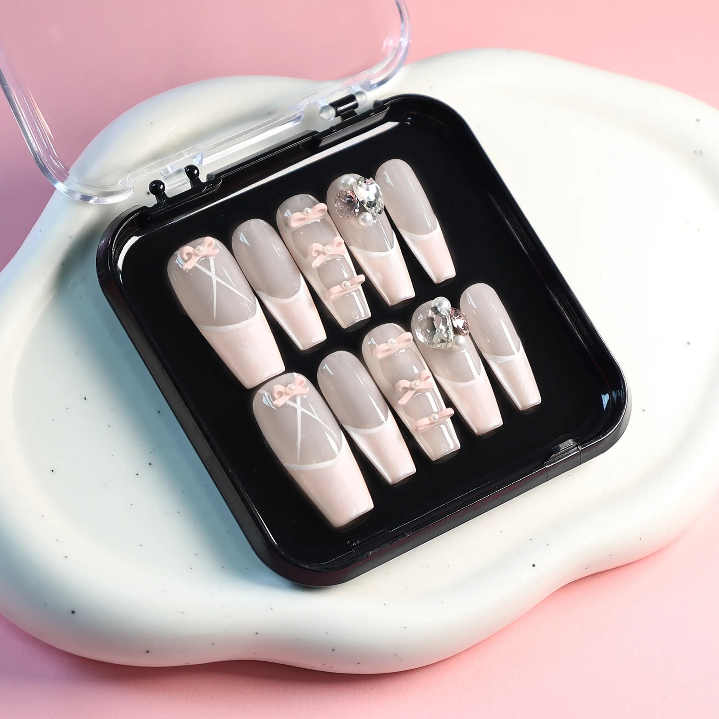 Square pink press-on nails with pearlescent French tips, 3D bows, rhinestones, and soft glam details. Perfect for weddings or elegant daily wear.