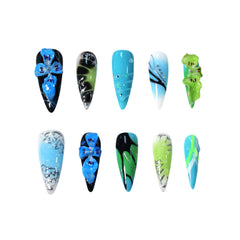 Vibrant long stiletto press-on nails with black, blue, and green tones, featuring 3D floral accents and rhinestone details.