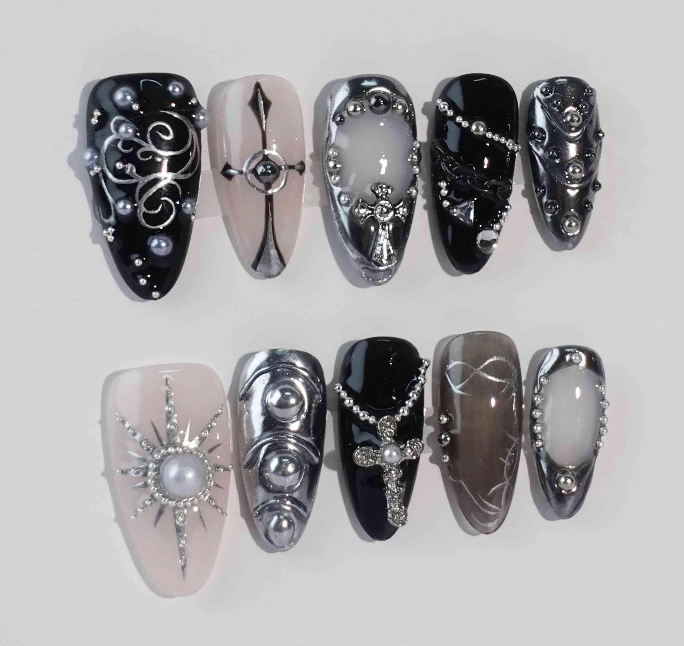 Gothic-style medium black almond press-on nails with silver baroque details and metal accents.