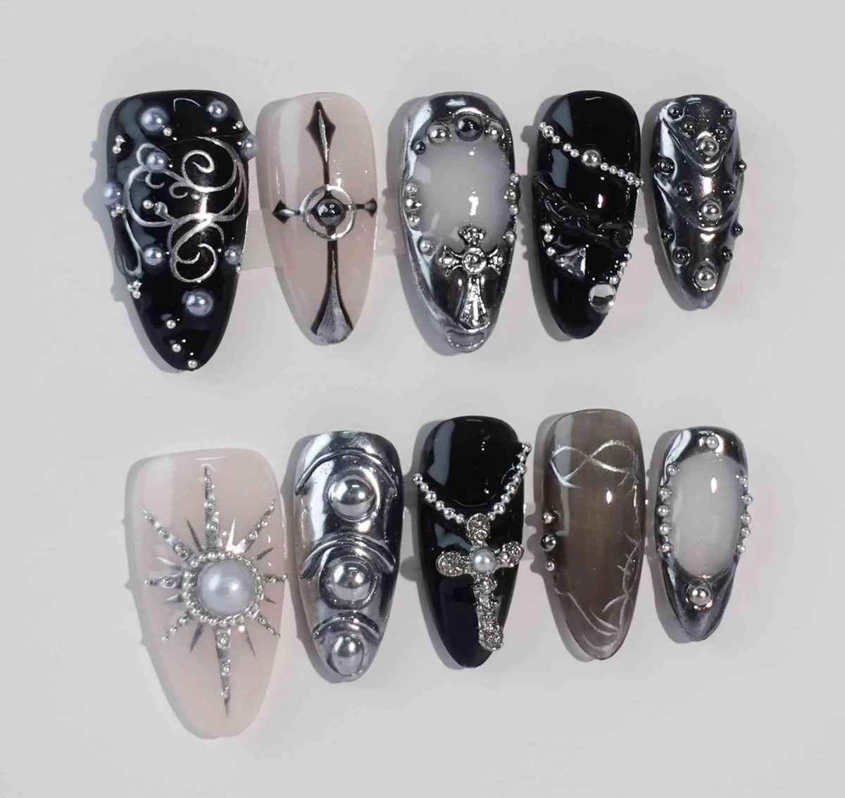 Gothic-style medium black almond press-on nails with silver baroque details and metal accents.