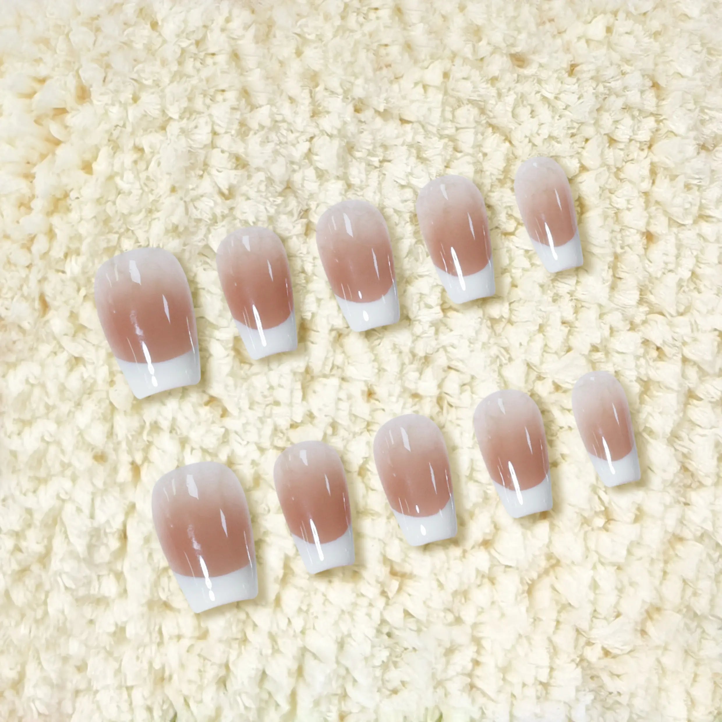 Press-on nails with nude base and bold white tips