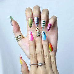 Hand model wearing blue almond nails with shimmering fish scale textures and metallic aqua tones