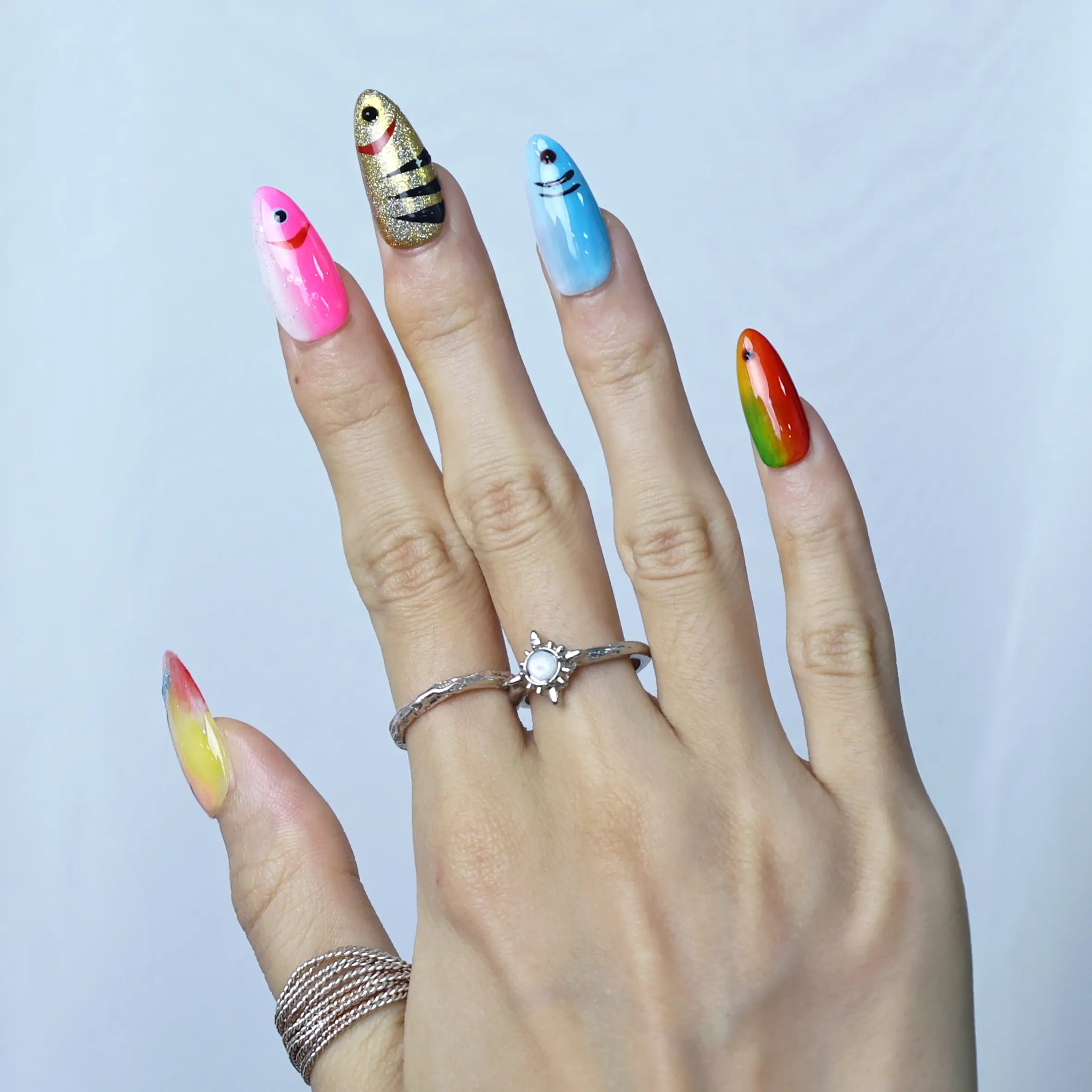 Mermaid-style summer nails in almond shape with textured fish scale detail and shiny metallic blue polish
